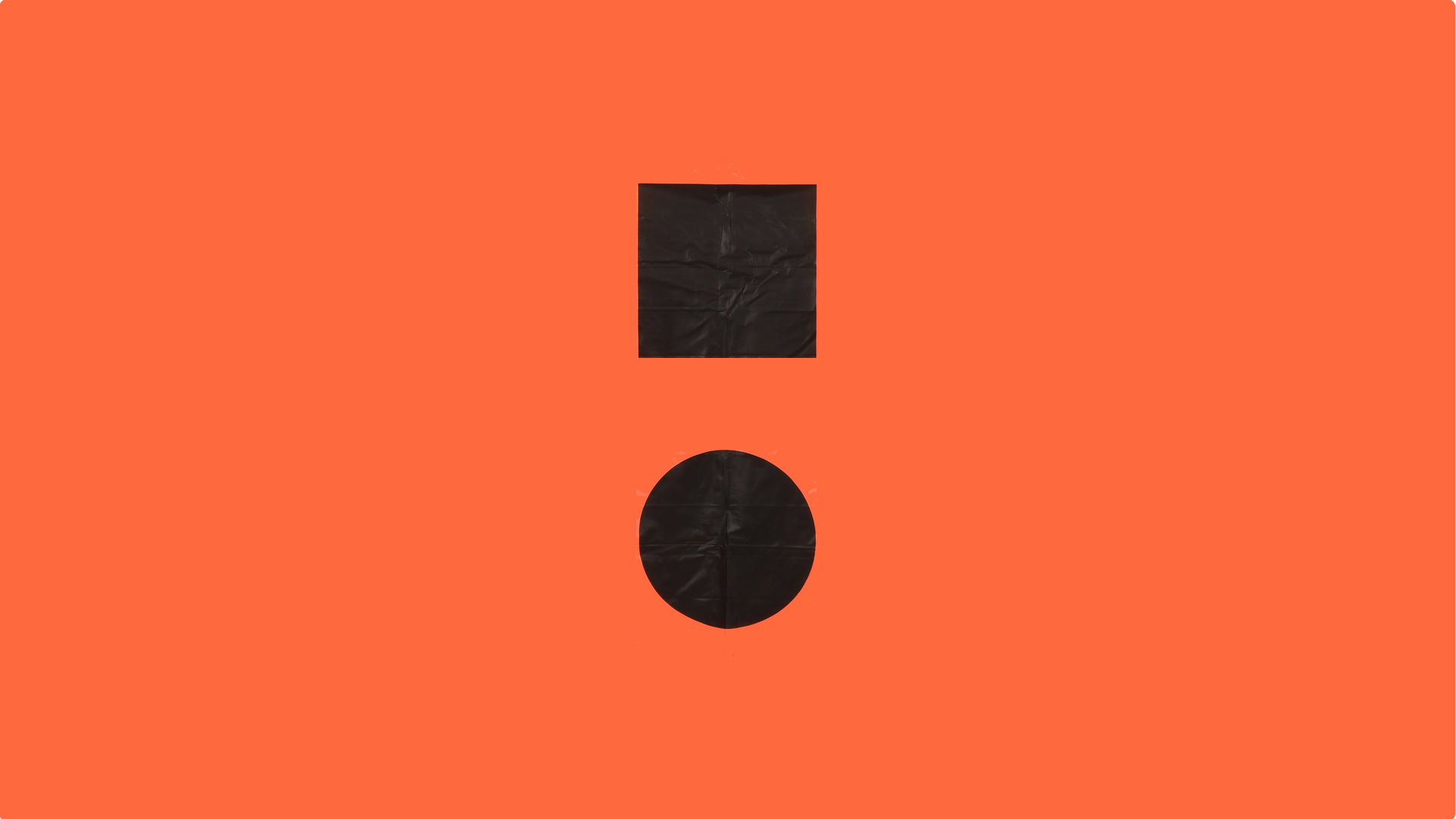 The internationally recognized distress flag; safety orange background with black square above black circle, simulating an exclamation point.